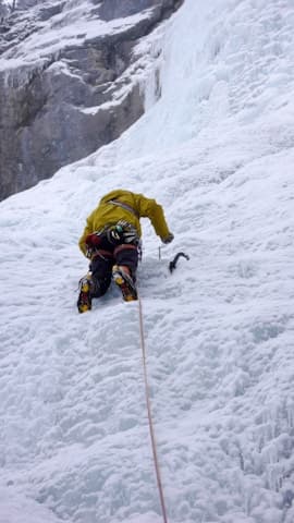 Climber ascending steep ice in the Khumbu Icefall